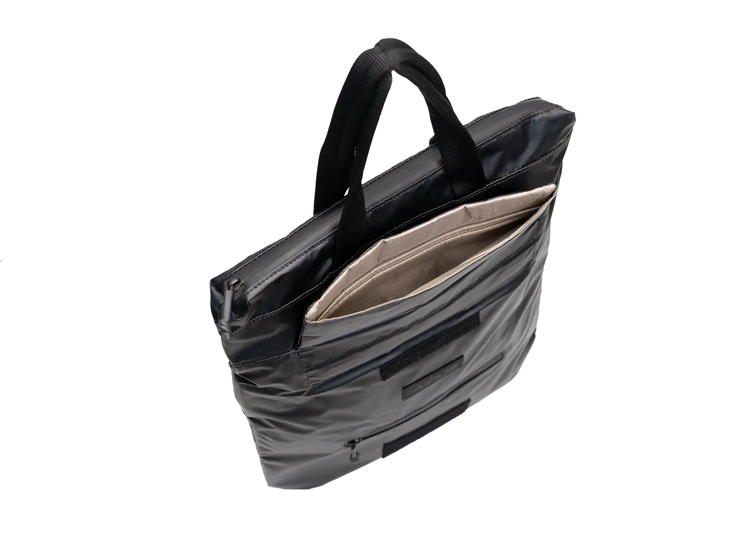 The AIRUS carry bag open at an angle, showing the pale Faraday lining inside the front pocket.