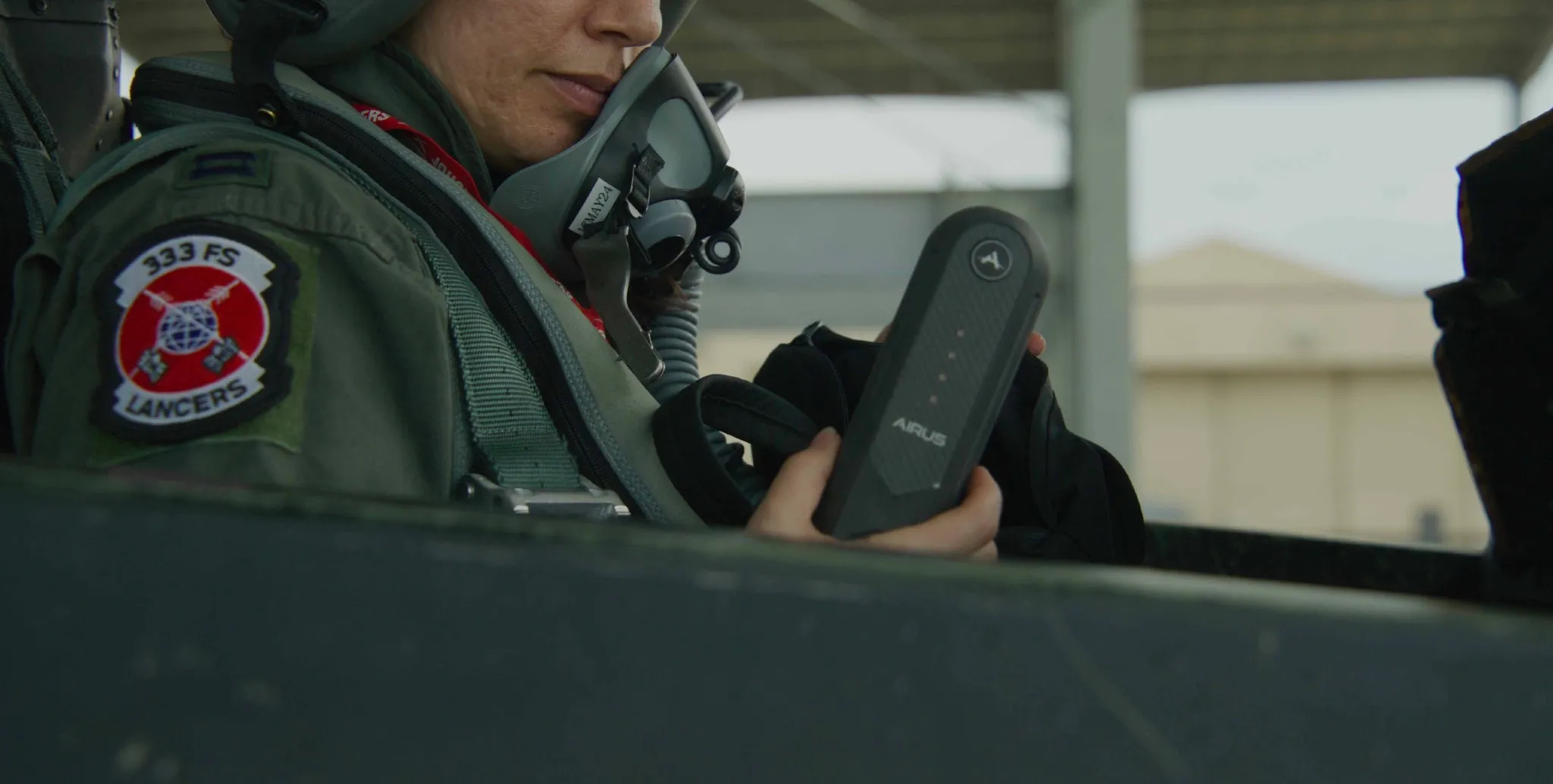 An aircrew member holds the AIRUS controller in the cockpit before a sortie.